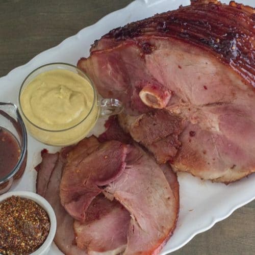 https://www.fodmapeveryday.com/wp-content/uploads/2018/11/Low-FODMAP-Cranberry-Hot-Pepper-Glazed-Ham-on-oval-white-platter-with-pan-juices-and-assorted-mustard-500x500.jpg