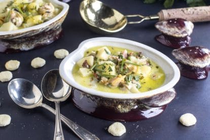 low FODMAP clam chowder with oyster crackers and silver spoons alongside