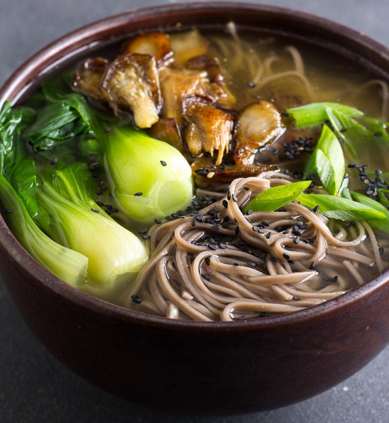 closeup Low FODMAP Soba Miso Soup with Bok Choy in brown ceramic bowl