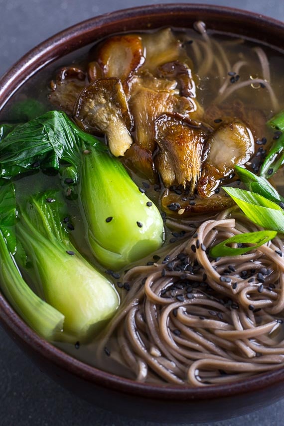 vertical image of Low FODMAP Soba Miso Soup with Bok Choy in brown ceramic bowl