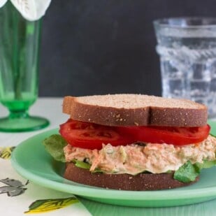 low FODMAP Cajun Tuna salad sandwich with lettuce and tomato on green plate