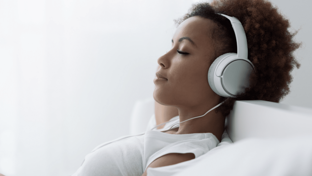 Woman laying back with headphones on.