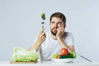 man holding fork with cucumber.