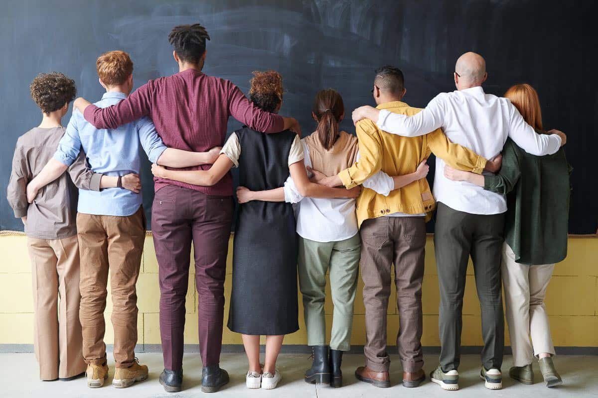 Group of people, arms around one another.