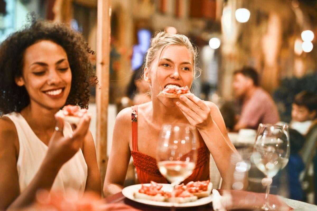 two young women eating in restaurant.