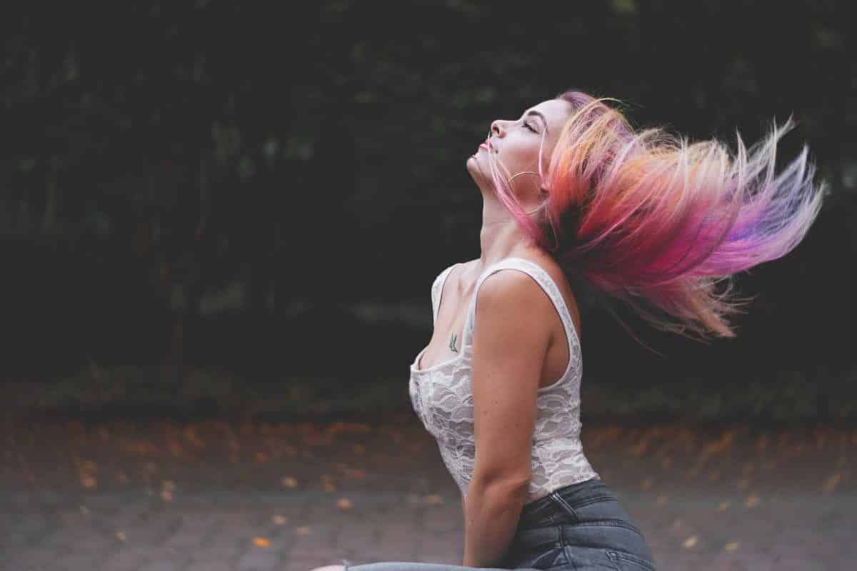 woman tossing rainbow hair.