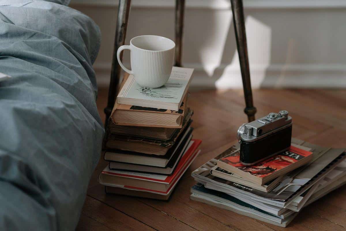 Bed on floor with blue cover. 