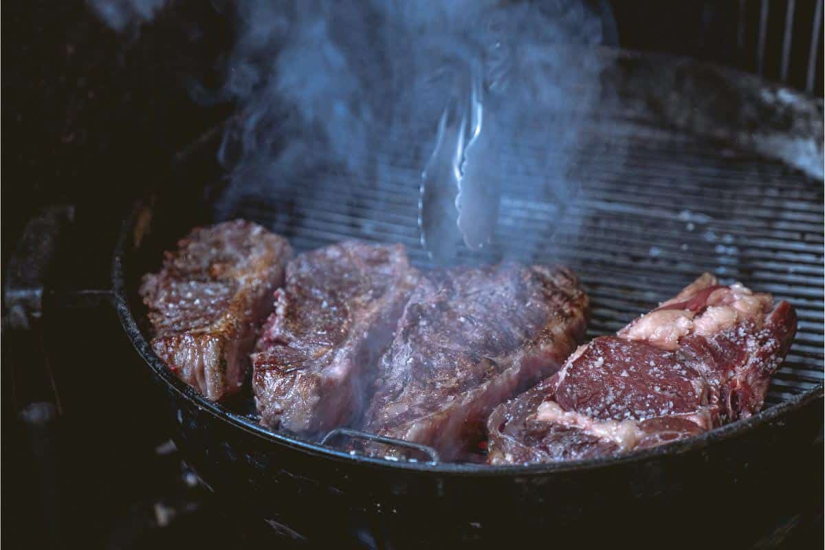 Multiple steaks on kettle grill. 