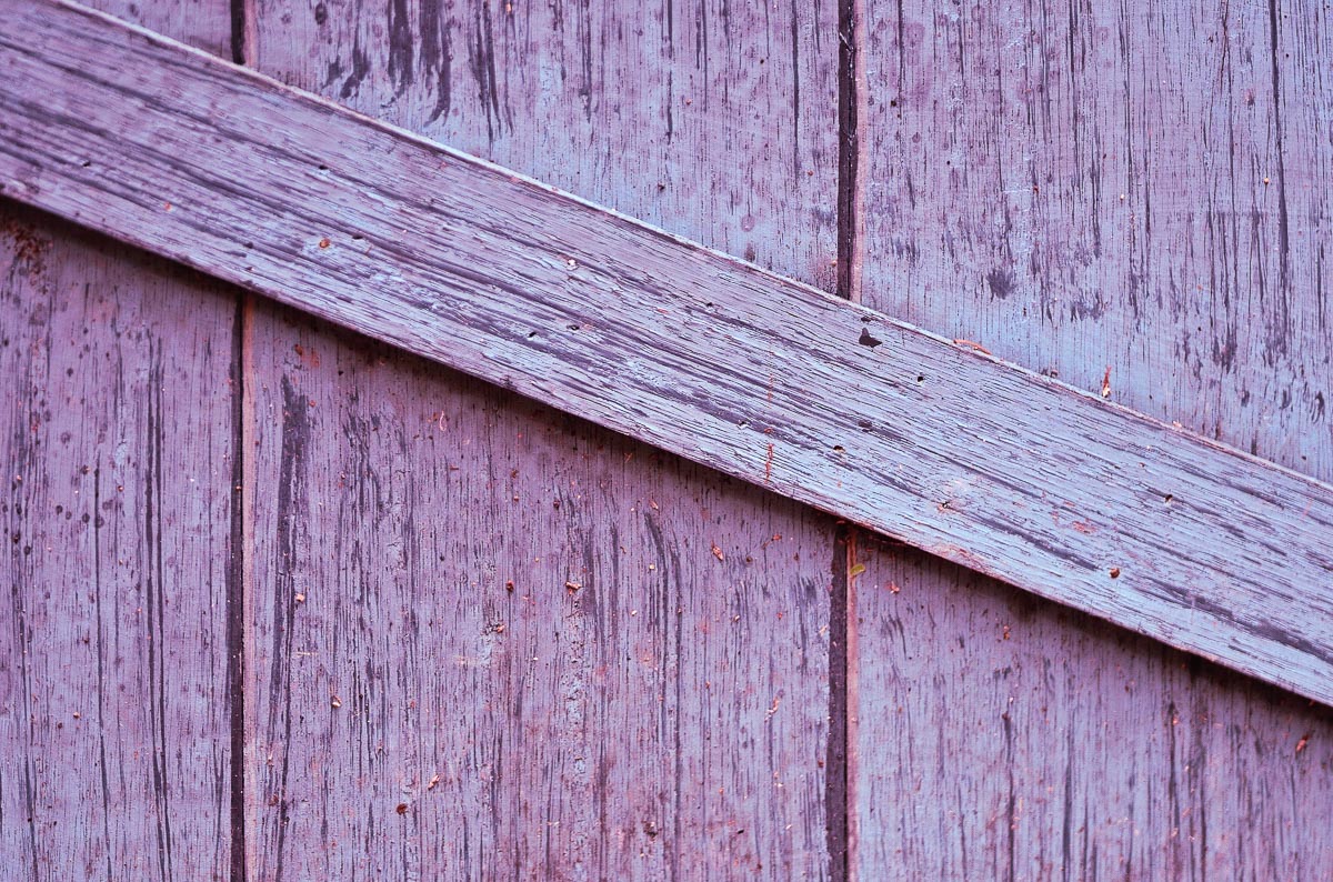 Purple wooden fence with diagonal piece.