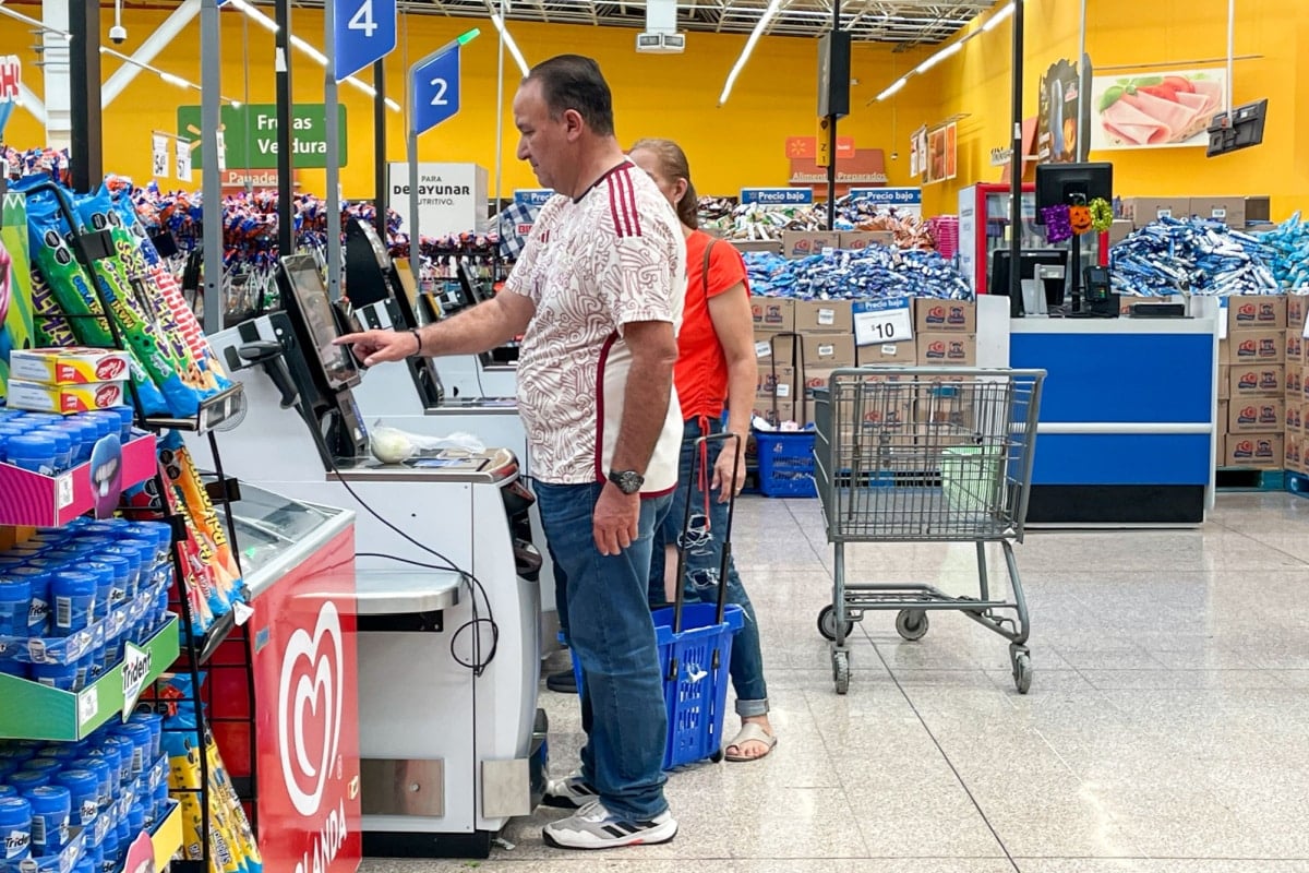 Customers paying at the self-service checkout.