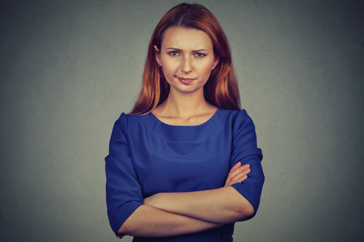 Closeup portrait of angry young woman, being skeptical, displeased isolated on gray wall background.