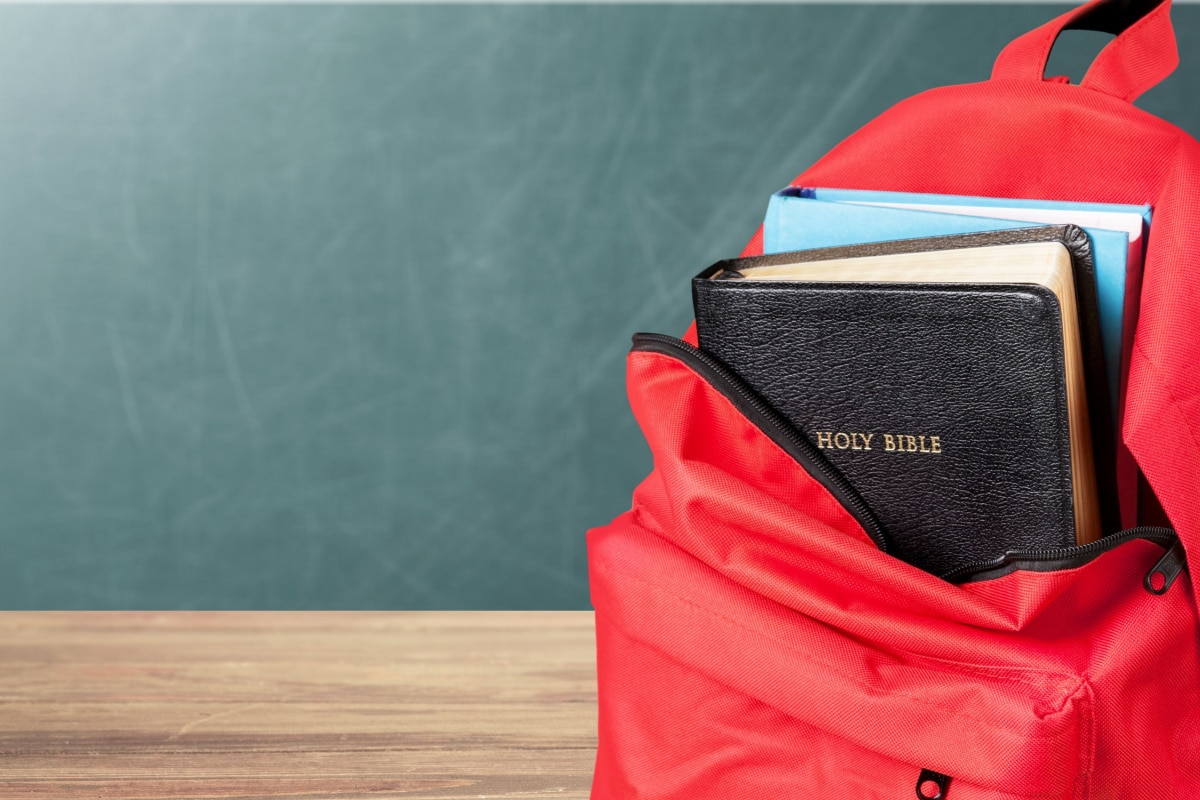 Red school Backpack with Bible Book.