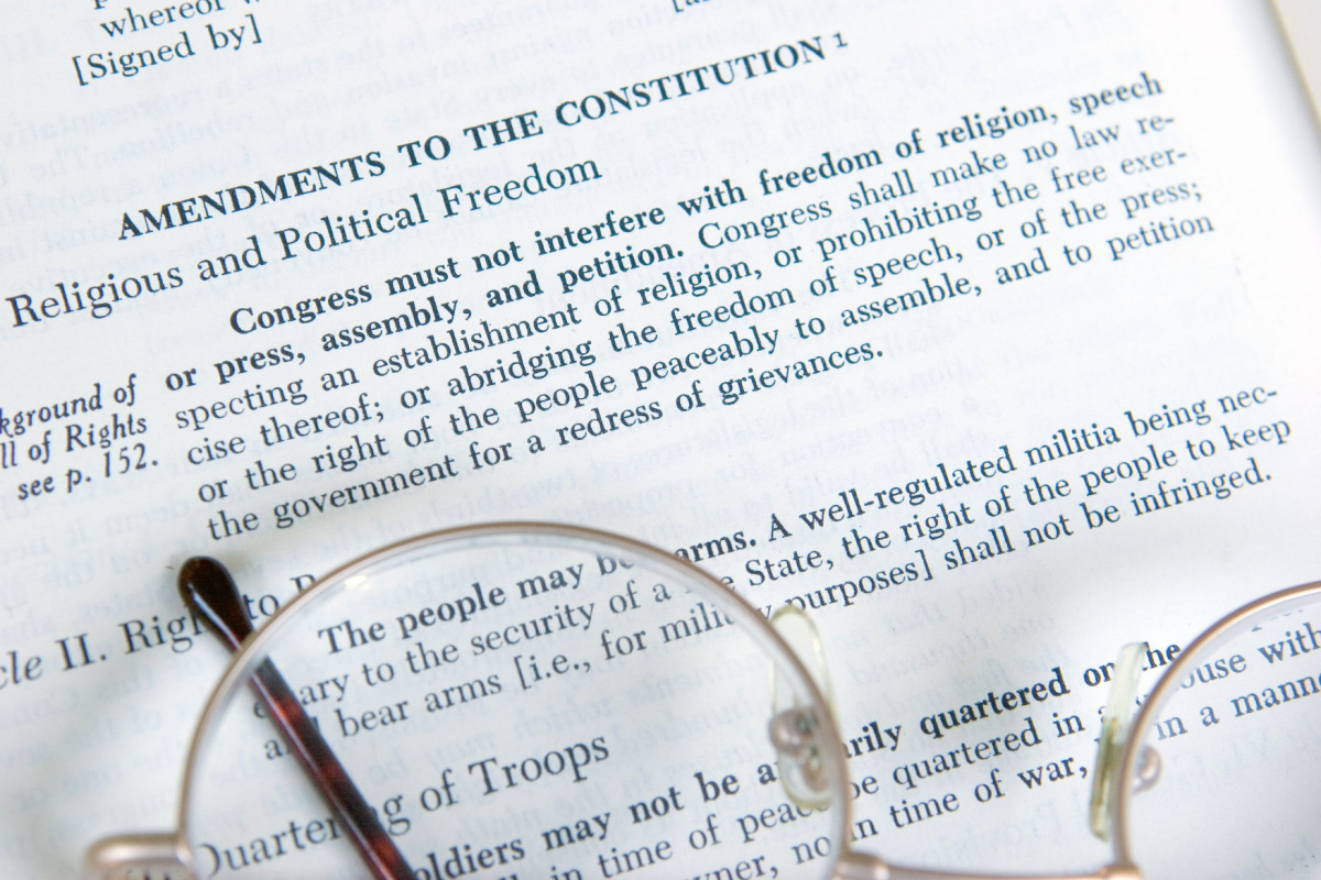 The First Amendment to the Constitution is shown on the page of a history book.