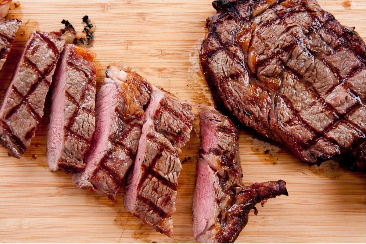 Steak with grill marks on board. 