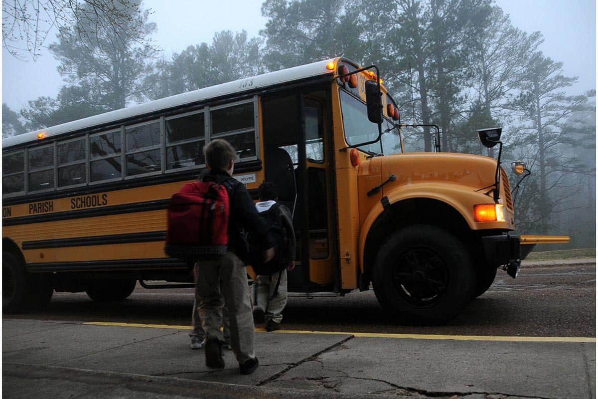 kids getting on school bus.