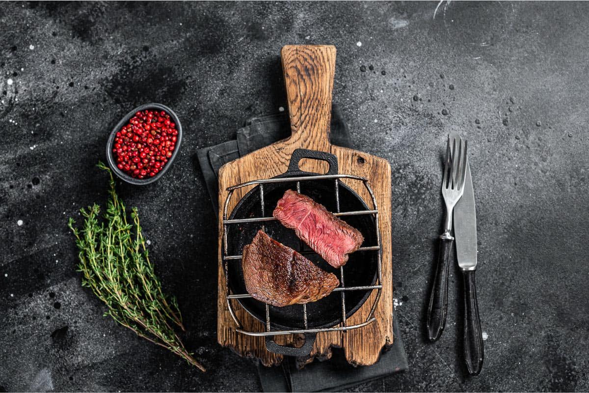 steak on board against grey background.