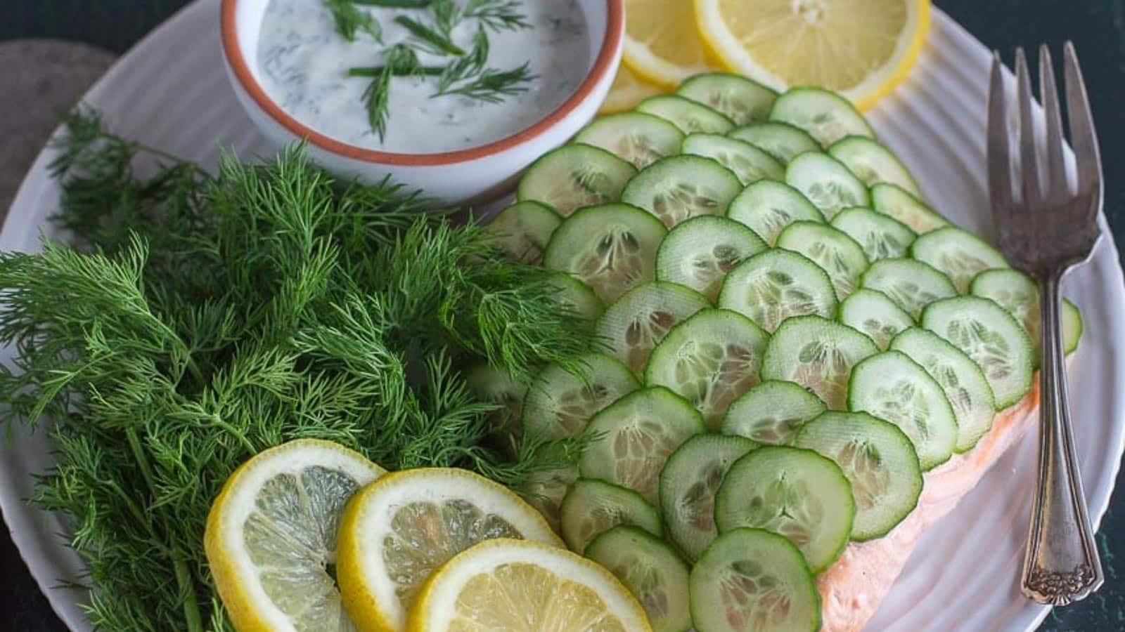 Poached-salmon-with-cucumber-scales-and-creamy-dill-sauce-on-a-white-plate.