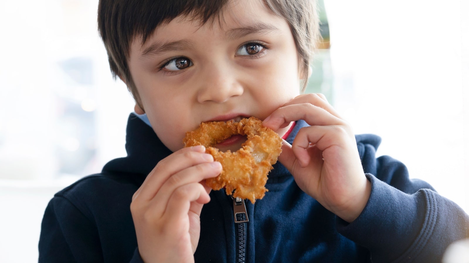 child eating onion rings. 