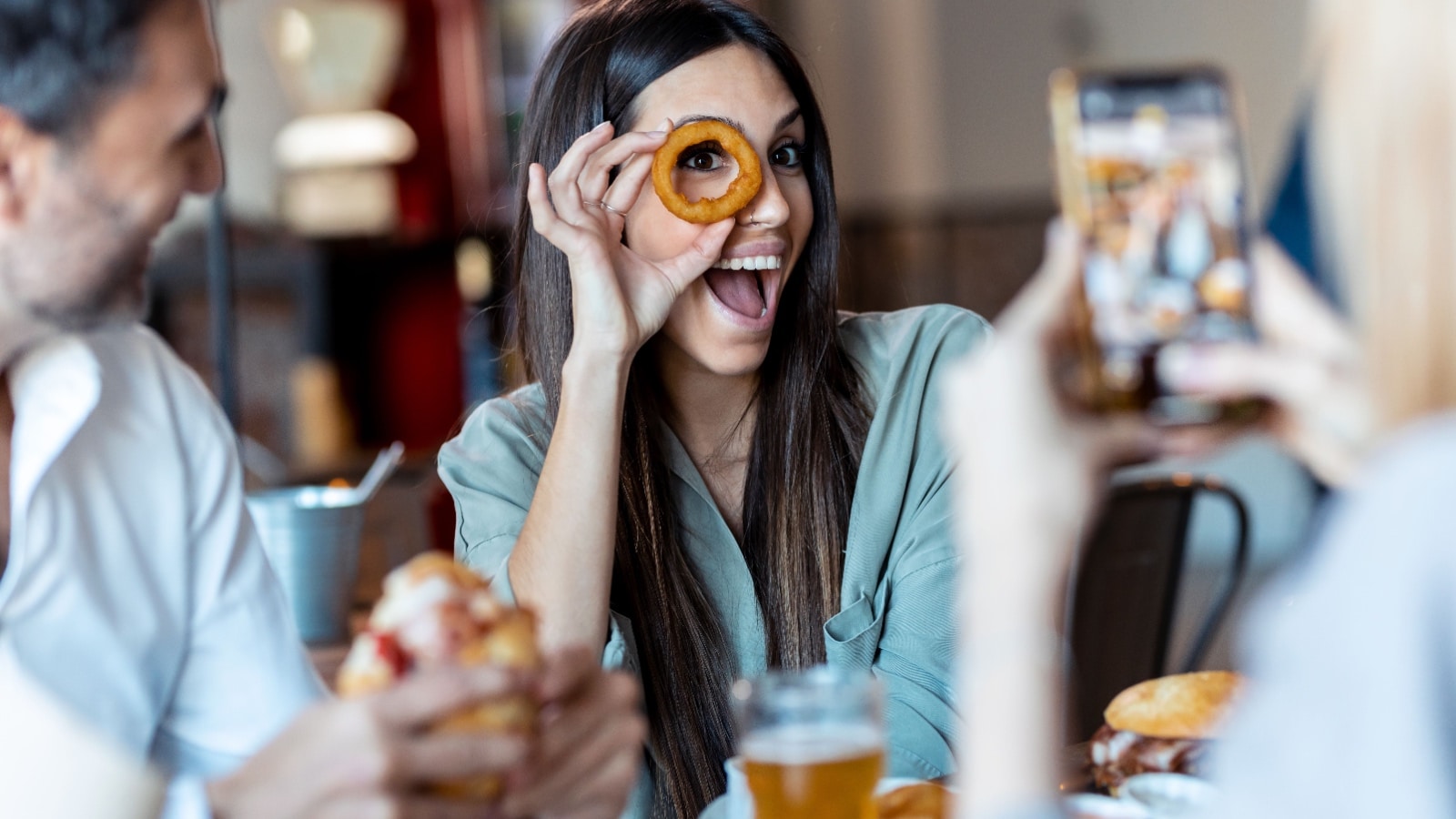 woman holding up onion ring.