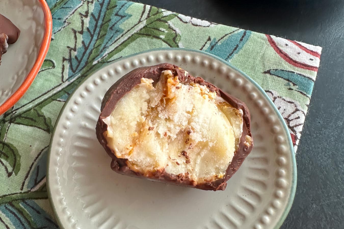 closeup Low FODMAP Frozen Chocolate-Dipped Peanut Butter Banana Bites on small plate.