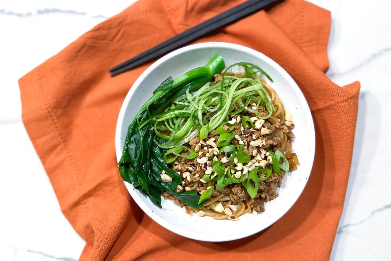 Low FODMAP Dan Dan Noodles in bowl with chopsticks.