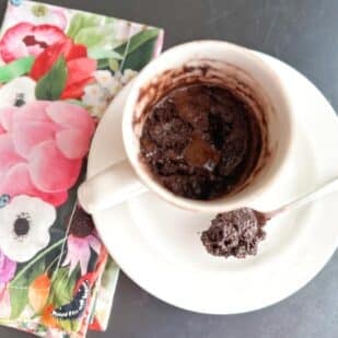 let's eat Low FODMAP High Protein Chocolate Mug Cake in ceramic mug with spoon.