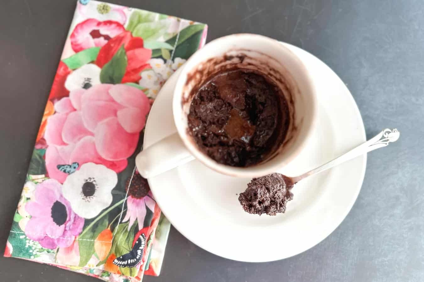 let's eat Low FODMAP High Protein Chocolate Mug Cake in ceramic mug with spoon.