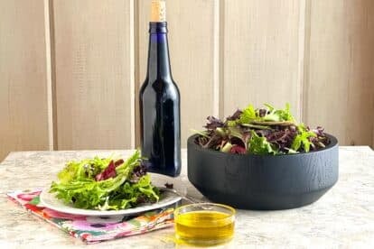 Low FODMAP Acidified Garlic-Infused Oil in bottle and dish. And salad.